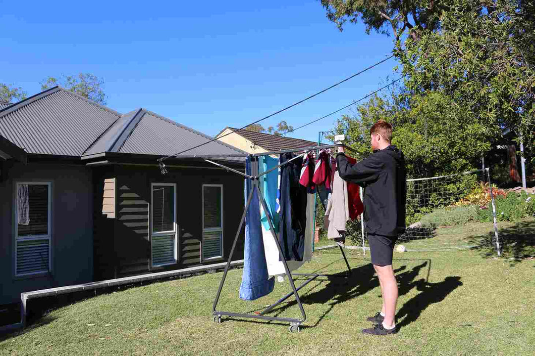 man hanging laundry on sunchaser mobile clothesline in sydney