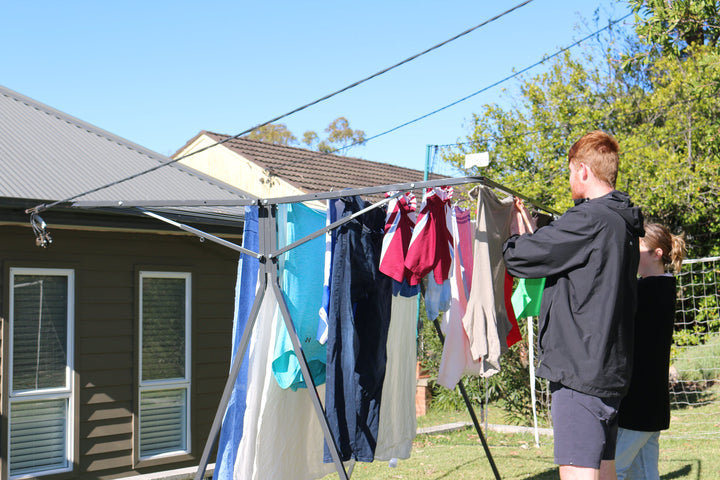 couple hanging washing on sunchaser mobile clothesline