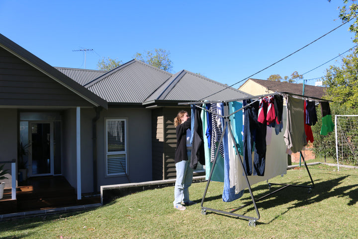 woman hanging washing on sunchaser mobile clothesline